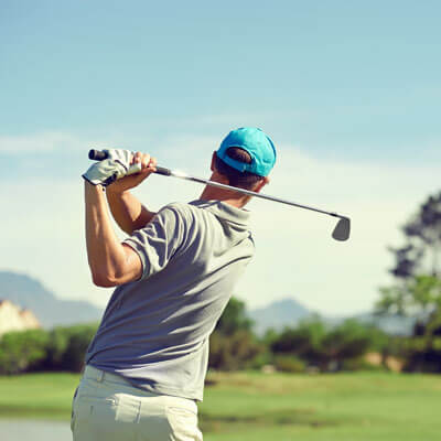 man golfing in a blue hat