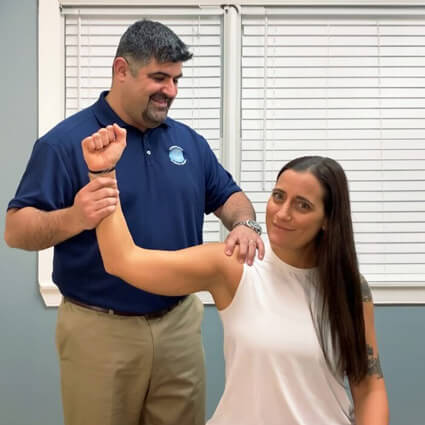Dr Adam with female patient doing an arm adjustment