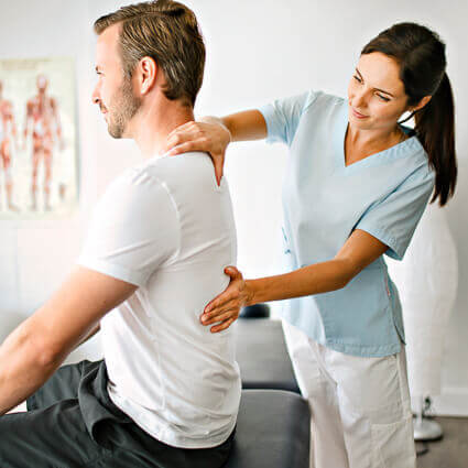 female-practitioner-in-blue-scrubs-examining-male-patients-back-sq