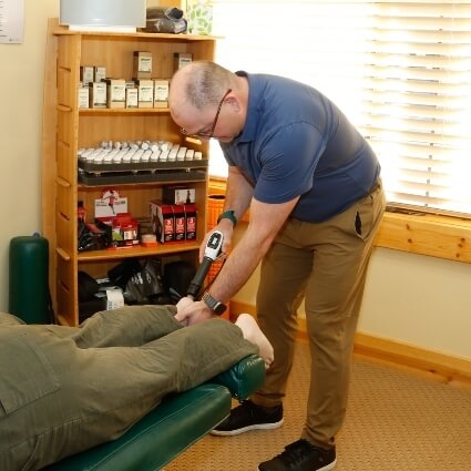Dr Michael using tool on patients leg