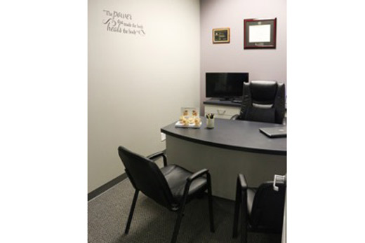 A chiropractic office with a desk