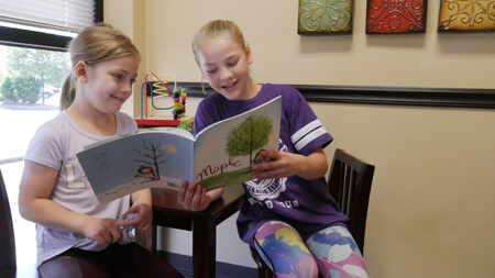 kids reading in waiting room smiling