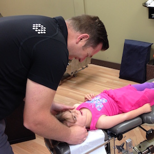 Dr. Tim adjusting a child