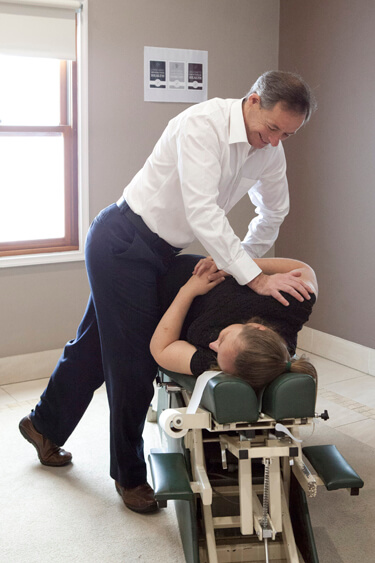 Dr Chacos adjusting a patient's lower back