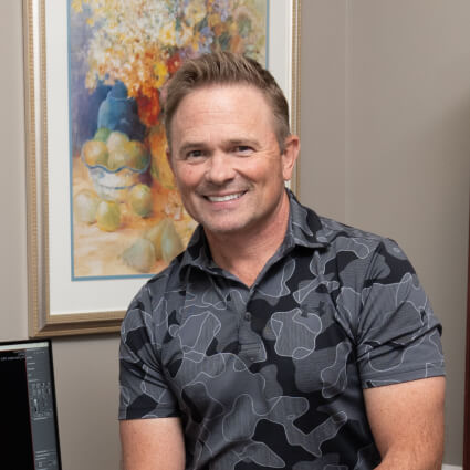 Belmont chiropractor Dr Wright leaning on his desk
