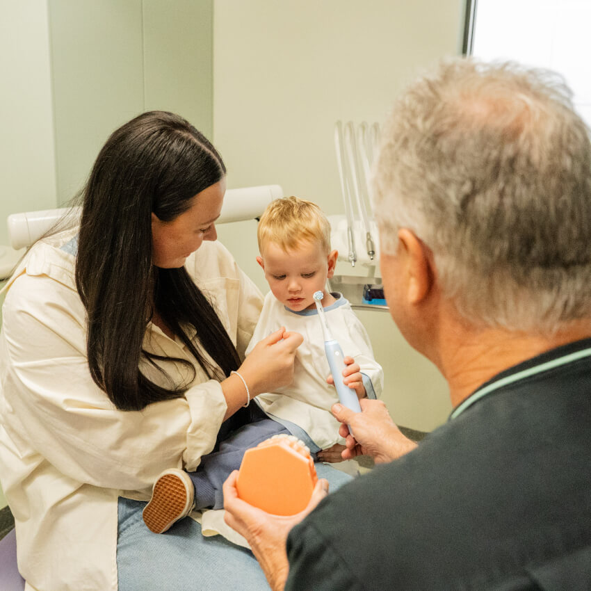 patient holding baby while talking to Dr Suster
