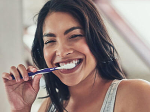 man flossing teeth in mirror