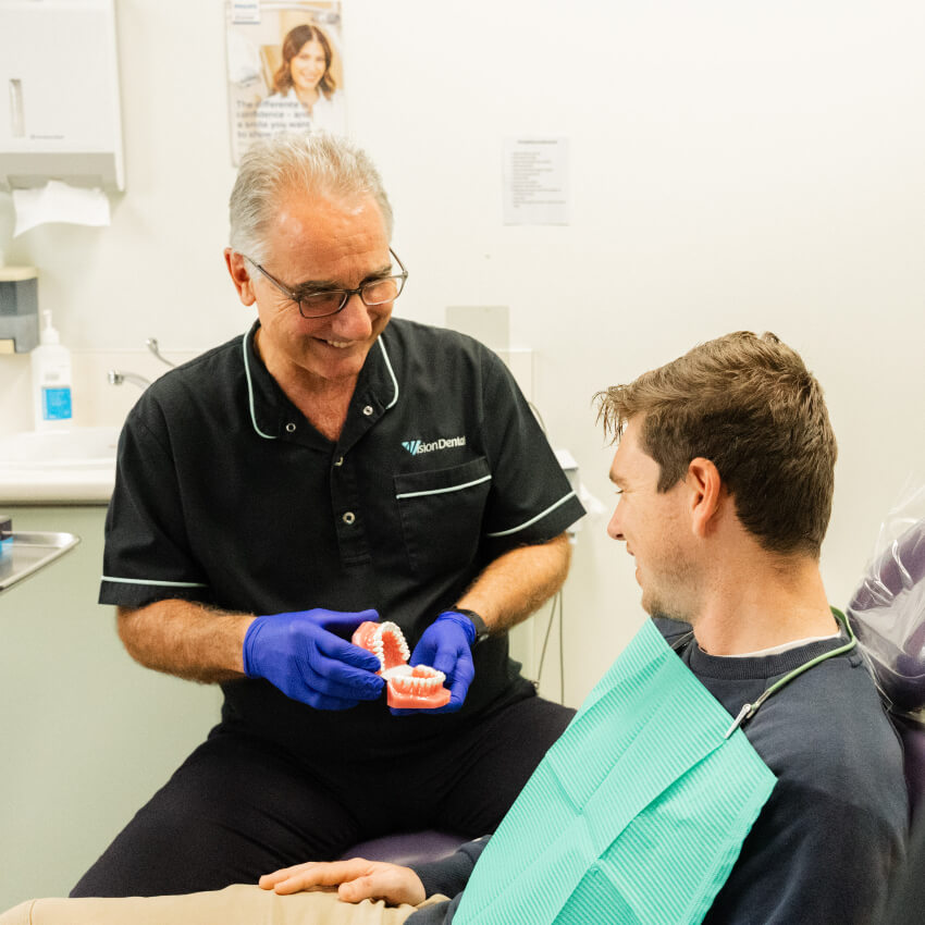 Dr Suster showing patient teeth model