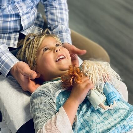 Smiling girl having neck adjusted