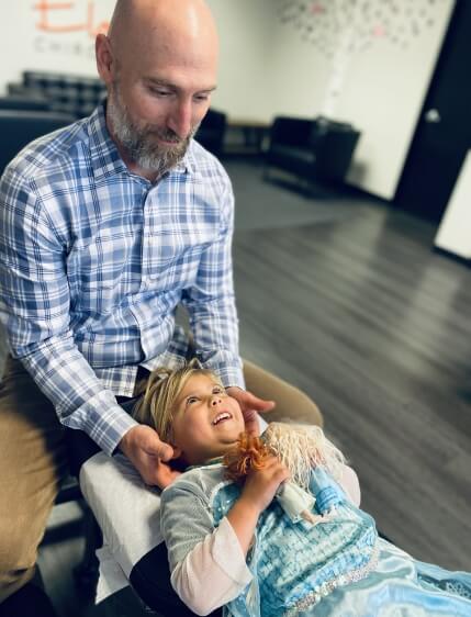 North Scottsdale chiropractor Dr. Thomas Tuzzolino adjusting kid patient