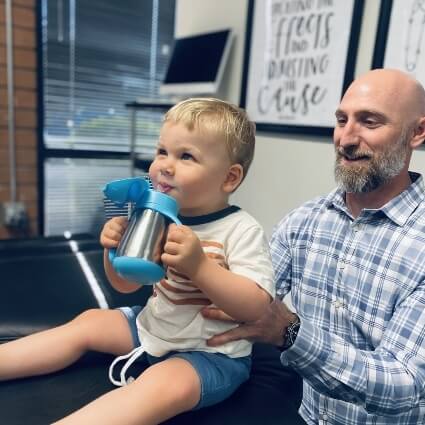 Dr Tuzzolino adjusting young kid