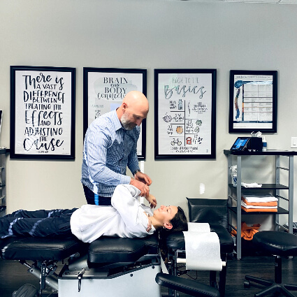 Chiropractor adjusting woman on table