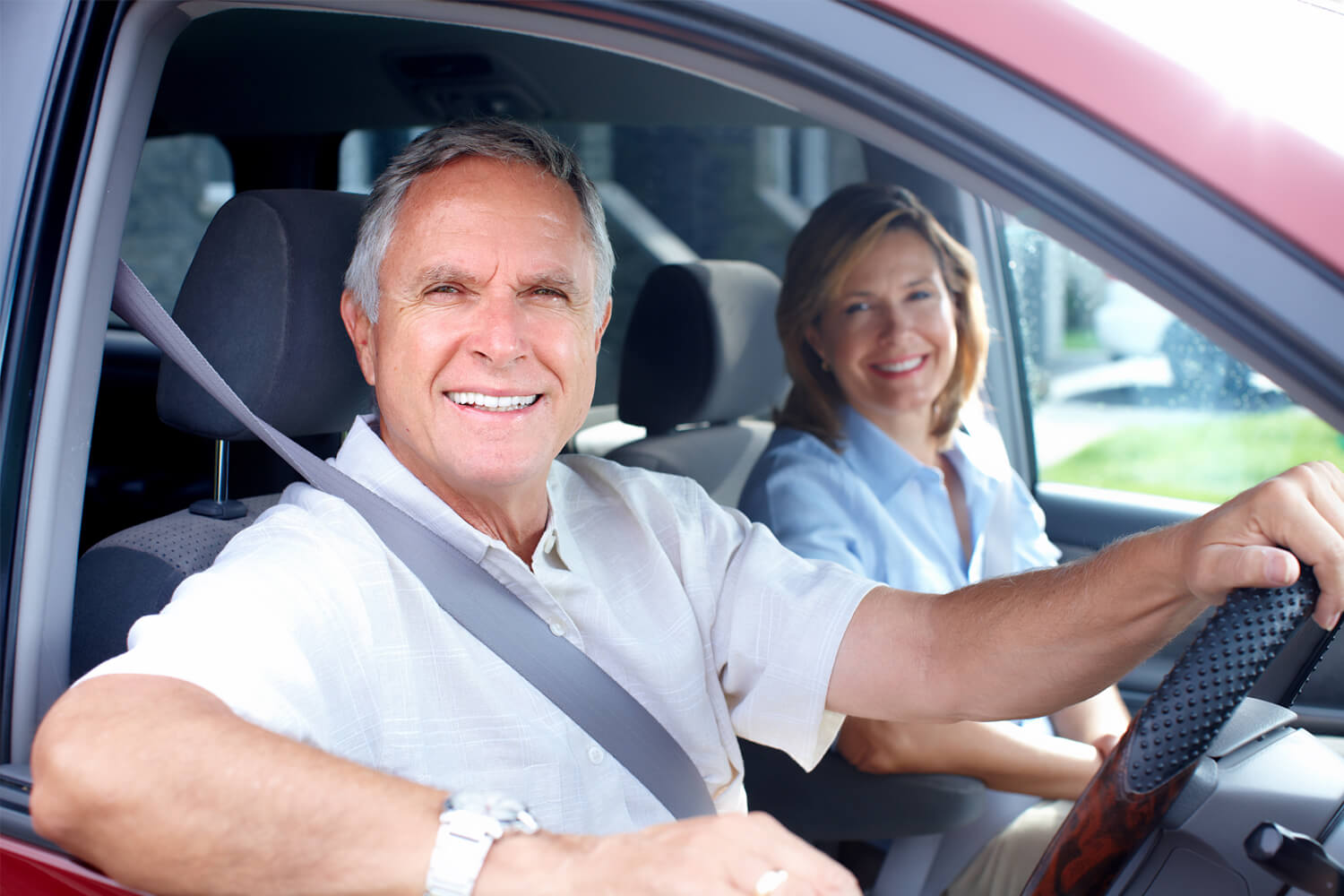 Smiling man and woman sitting in a car