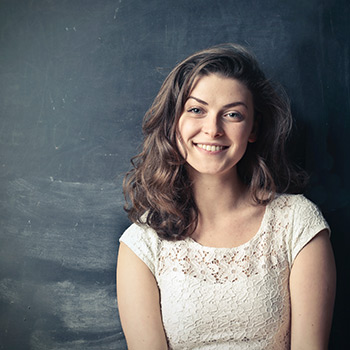 teenage girl smiling in front of a blackboard