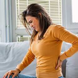 woman on couch with sciatic pain
