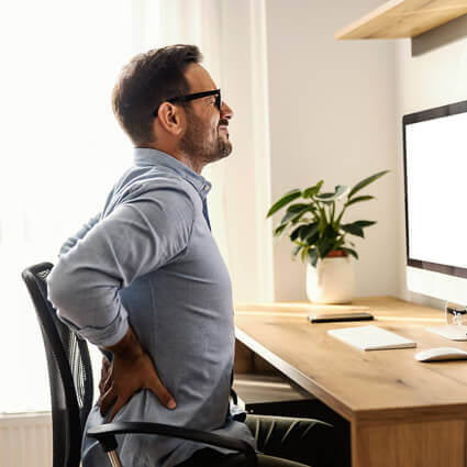 man in ohome office with low back pain