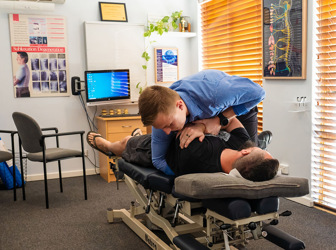 chiropractor adjusting persons shoulder