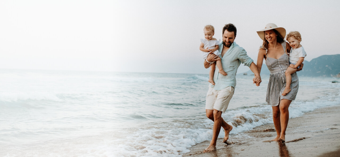 Family of four walking along the beach