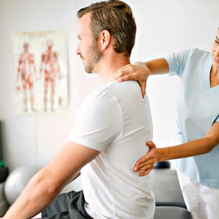 Male patient getting his back assessed