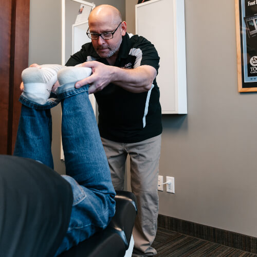 Chiropractor stretching patient's legs
