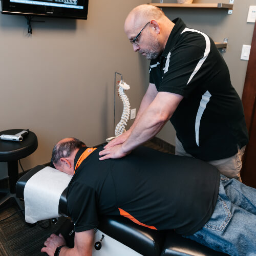 Chiropractor adjusting patient's upper-back