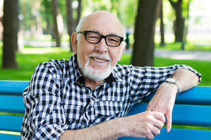older man sitting on a bench and smiling