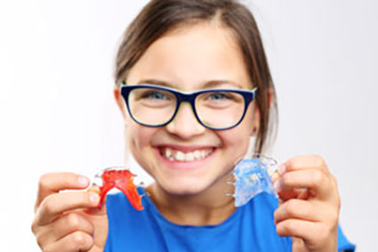 girl holding retainers