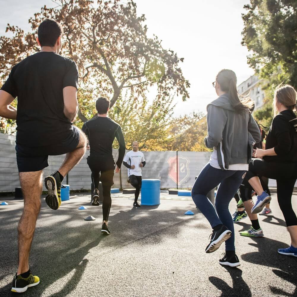 man in black t-shirt and black shorts running on road during daytime