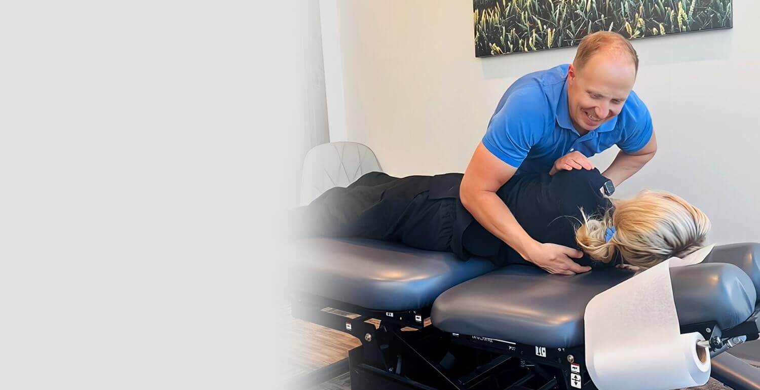 Okotoks chiropractor Dr Chris adjusting patients back