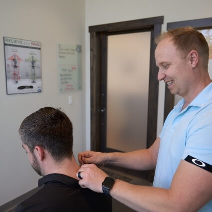 Dr Chris using tool on persons neck