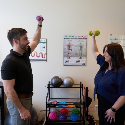 Dr Cody lifting weights with patient