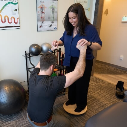 Dr Cody helping patient on balance tool