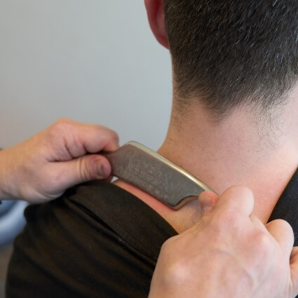 IASTM tool being used on persons neck