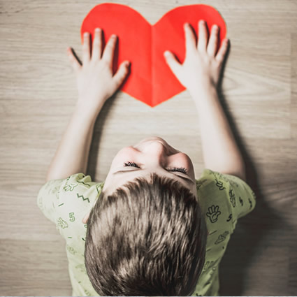 Boy top angle paper heart on desk