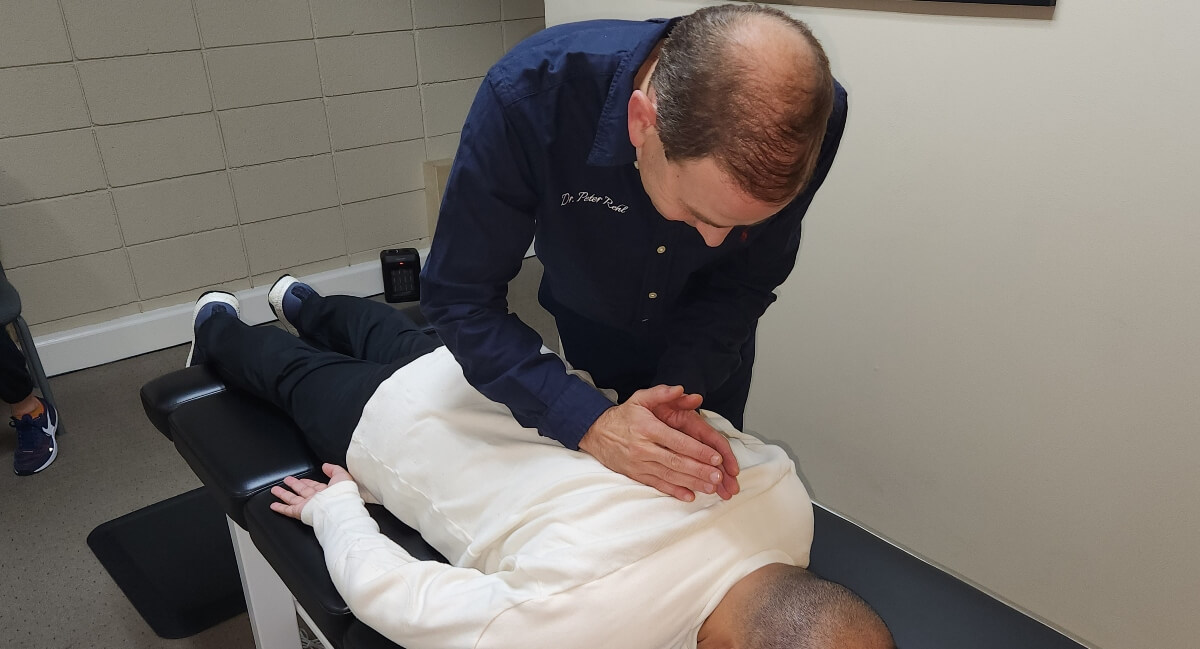 Oakland chiropractor adjusting patient's back