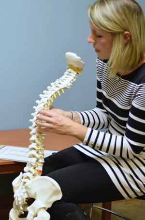 Chiropractor Green Bay Dr. Leah Hetebrueg holding spine model