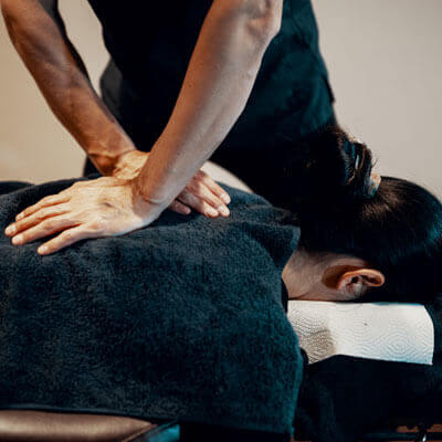 Chiropractor massaging patient's back