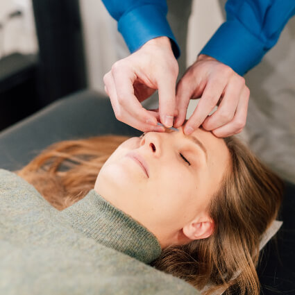 Acupuncture on woman's forehead