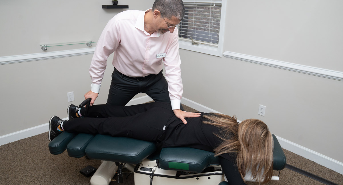 Dr. Shaye adjusting a patient's back on a chiropractic table