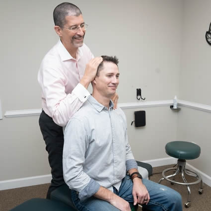 Williamsburg Chiropractor Dr. Shaye adjusting man's neck