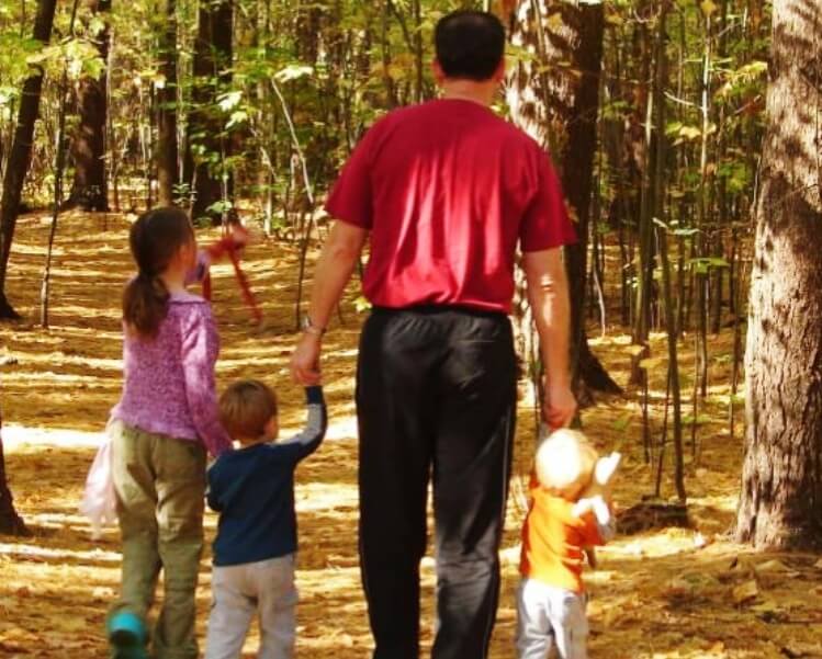 family walking in the woods