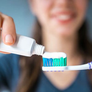 Applying toothpaste on toothbrush