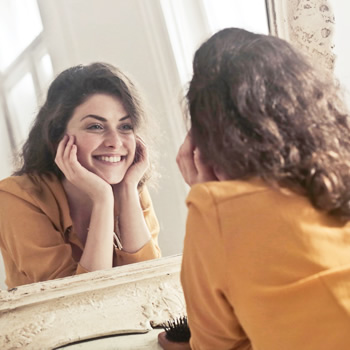 woman smiling in front of mirror