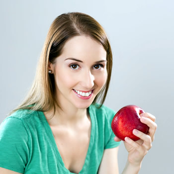woman smiling with apple at hand