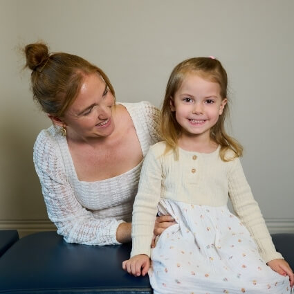 Dr Kaitlyn smiling with a child