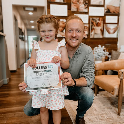 Dr Jason and girl holding certificate