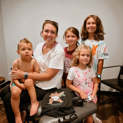 Holly Springs female patient and her kids sitting on an adjustment table