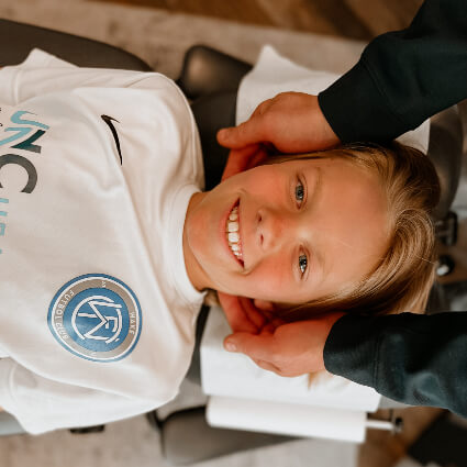 Smiling child getting a neck adjustment