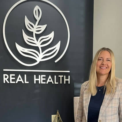 Chiropractor standing by logo