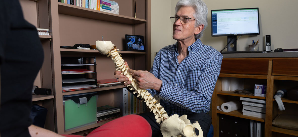 West Lake Hills Chiropractor Dr. Sanders holding spine model